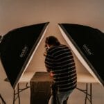 Czy fotografia to sztuka czy rzemiosło? Krótkie spojrzenie w historię sporu Fotograf przy pracy w studiu z oświetleniem softbox
