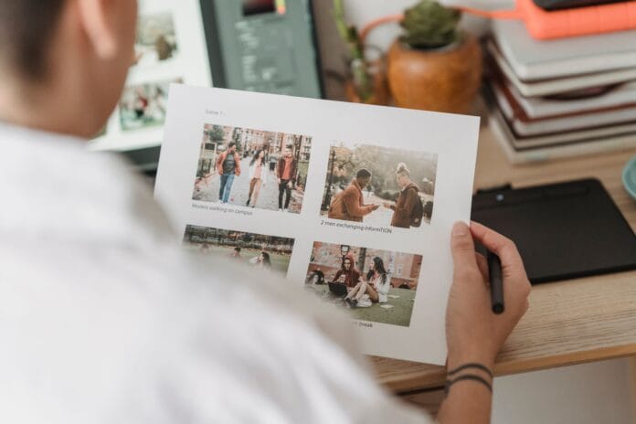 Fotografka układa wydruki zdjęć na biurku obok laptopa Fotografka układa wydruki zdjęć na biurku obok laptopa